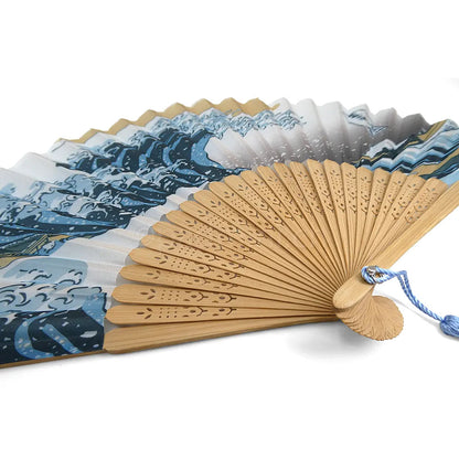 Detailansicht eines japanischen Handfächers mit Hokusais grosser Welle, bedrucktem Stoff und filigran verzierter Bambusarmatur.