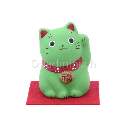Japanische Maneki-Neko Glückskatze in Grün mit roten Details, erhobener Pfote und Glückszeichen auf der Halsplakette.