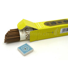 Japanische Morning Star Patchouli Räucherstäbchen von Nippon Kodo mit geöffneter Packung und kleinem Keramik-Räucherstäbchenhalter.